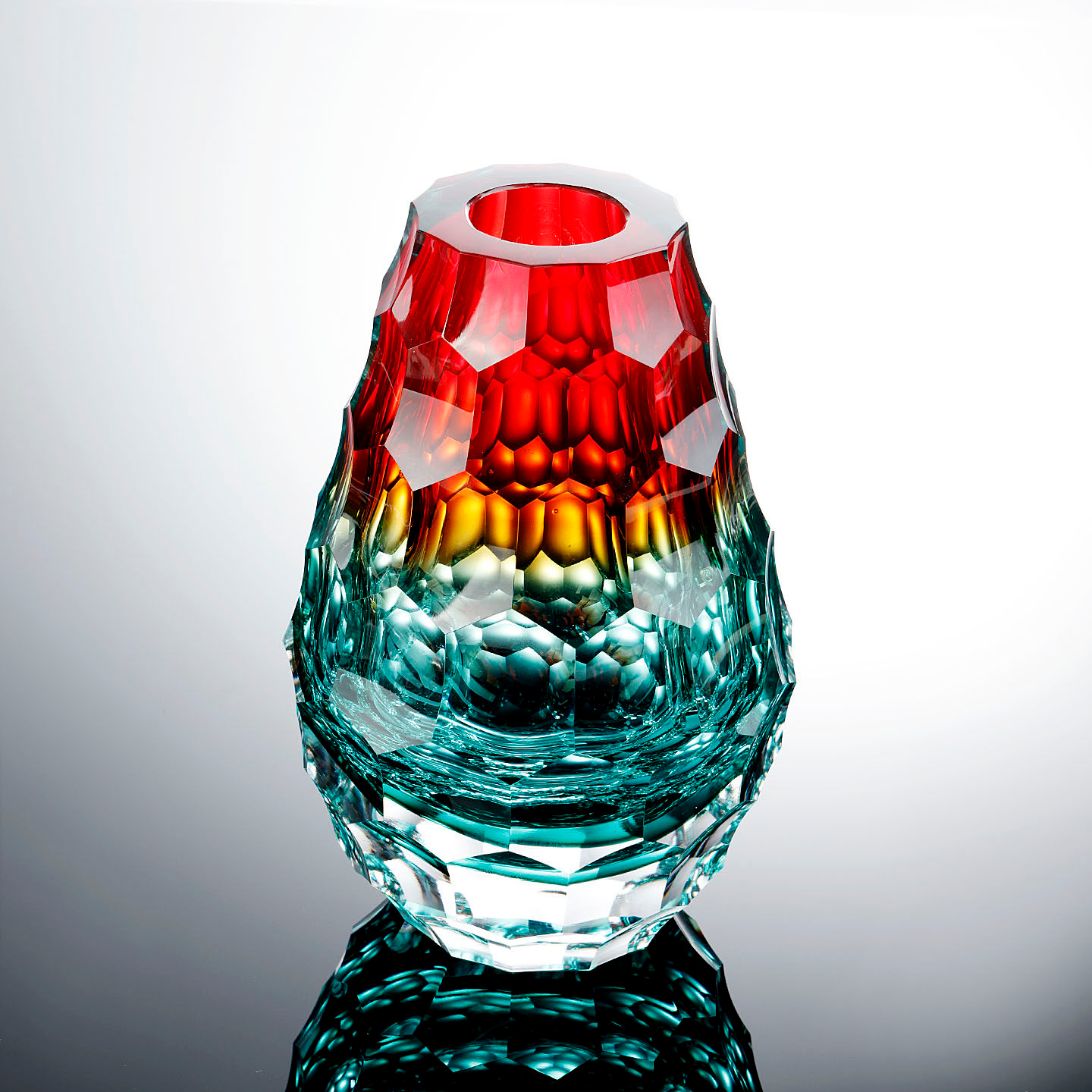 Front view of red and teal faceted glass vase