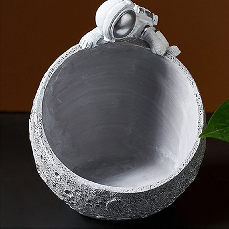 Gold astronaut moon bowl holding watch and lipstick