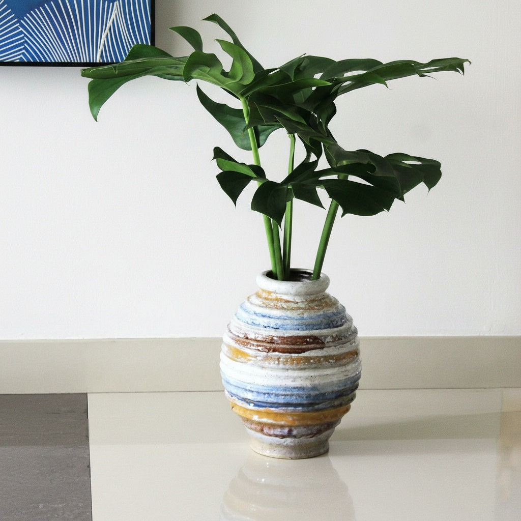 Full view of glazed ribbed vase with green leaves