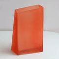 Front view of tall ribbed orange glass vase