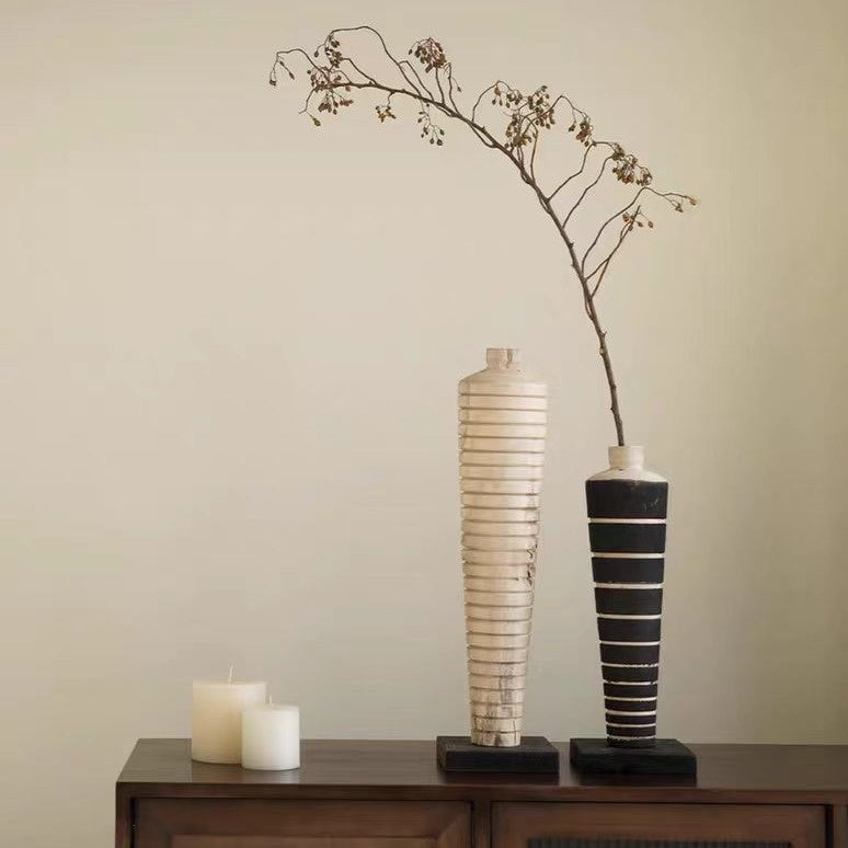 Ribbed wood and black grooved bottle sculptures on console table