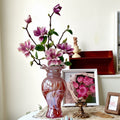 Rose glass vase with ruffled rim holding magnolia flowers