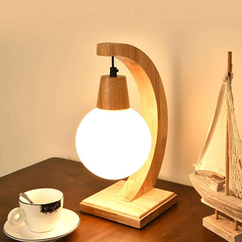 Angled view of curved wood lamp stand and base