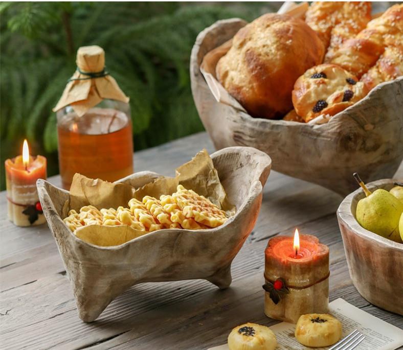 Wooden trough bowl serving waffles and pastries on a cozy table setting
