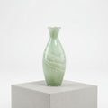 Studio shot of tall sage green marbled glass vase against white background