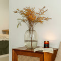 Sepia glass oval vase styled with dried botanicals on wooden cabinet
