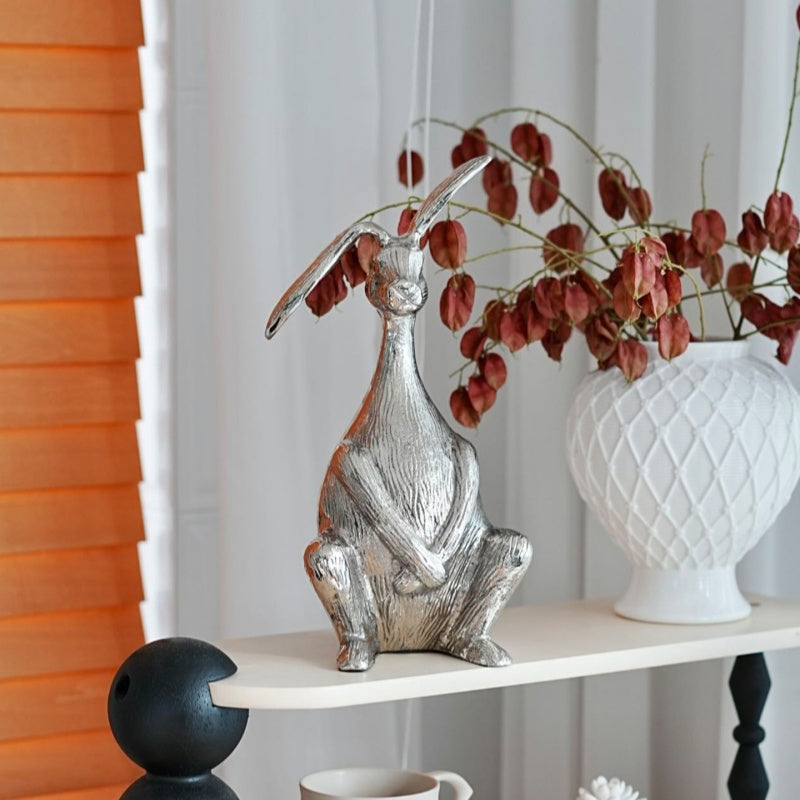 Side view of textured metal rabbit figurine on shelf