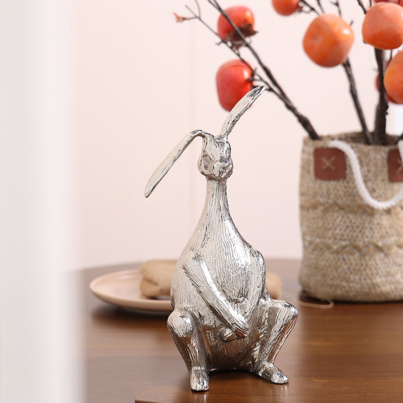 Back angle of silver hare statue near vase