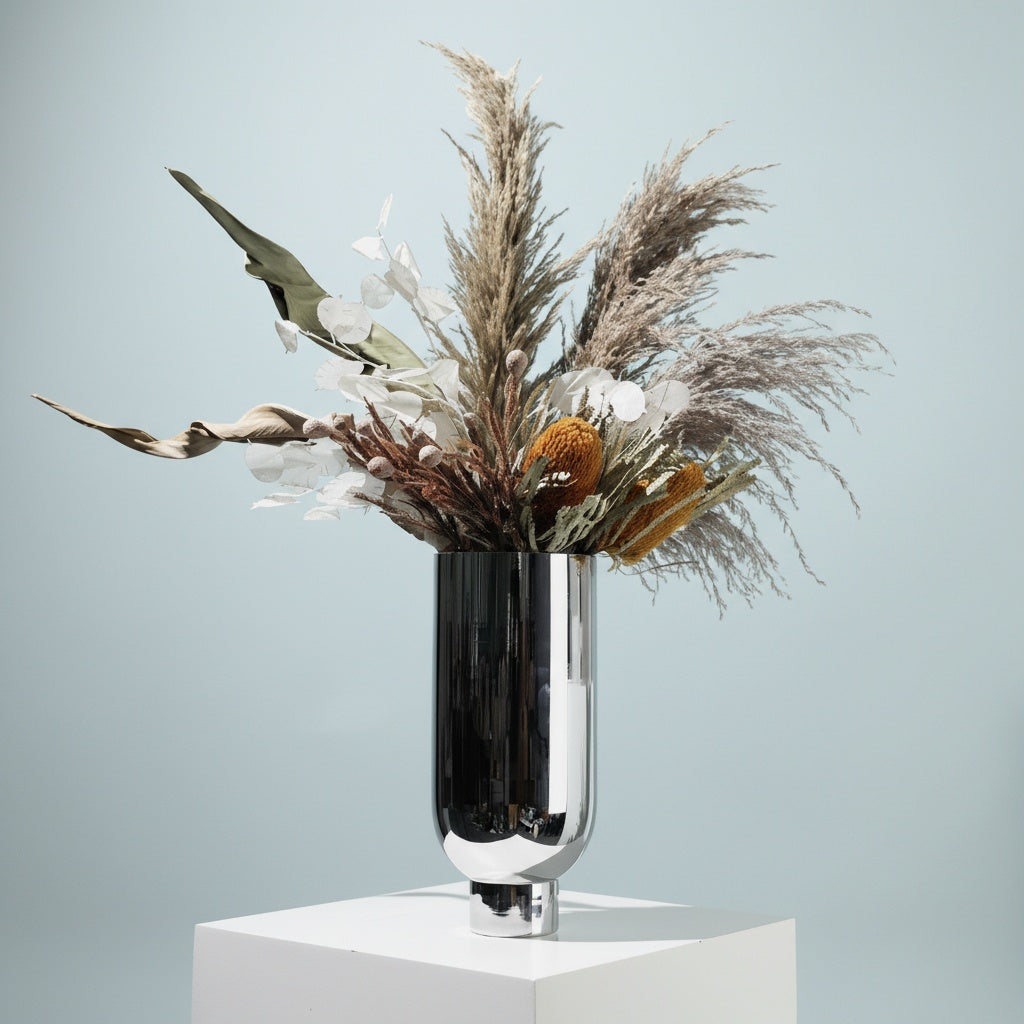 Tall silver chrome vase with dried flowers arrangement
