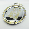 High angle view of oval silver serving tray featuring central gold etching and two-tone handles