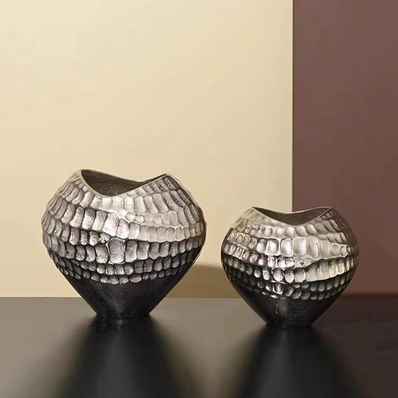Two silver ceramic vases with hammered texture on dark surface