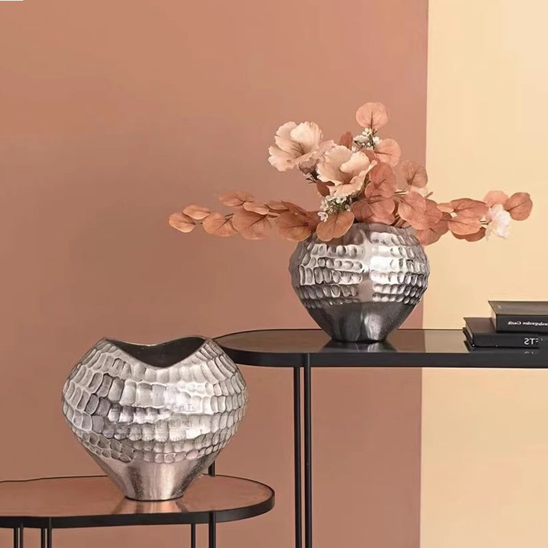Silver hammered ceramic vase with pink flowers on console table