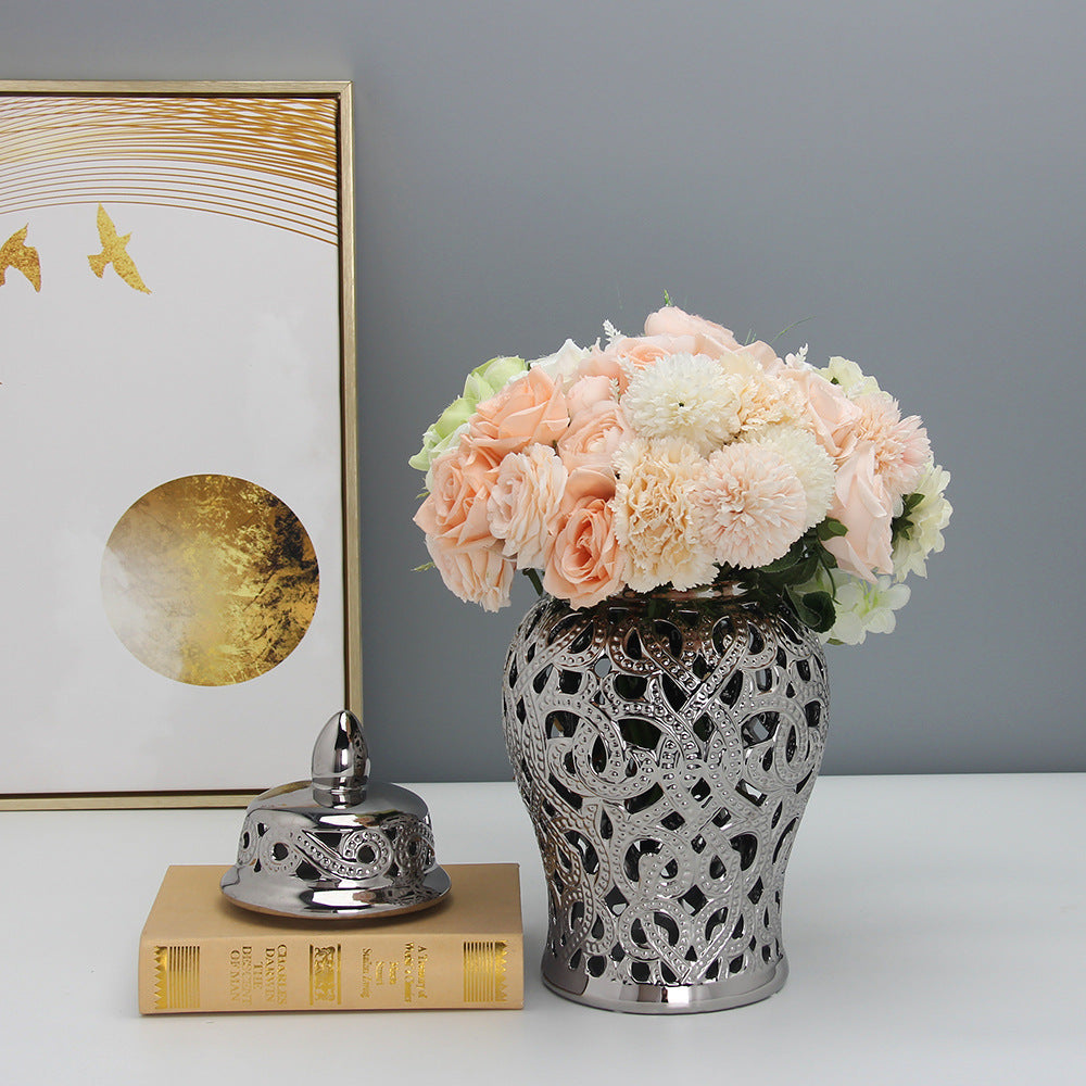 Silver metal lattice ginger jar with flowers on table