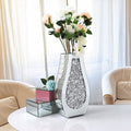 Silver mirrored crushed diamond teardrop vase with flowers on table