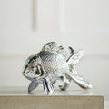 Detailed close up of textured scales on silver fish statue