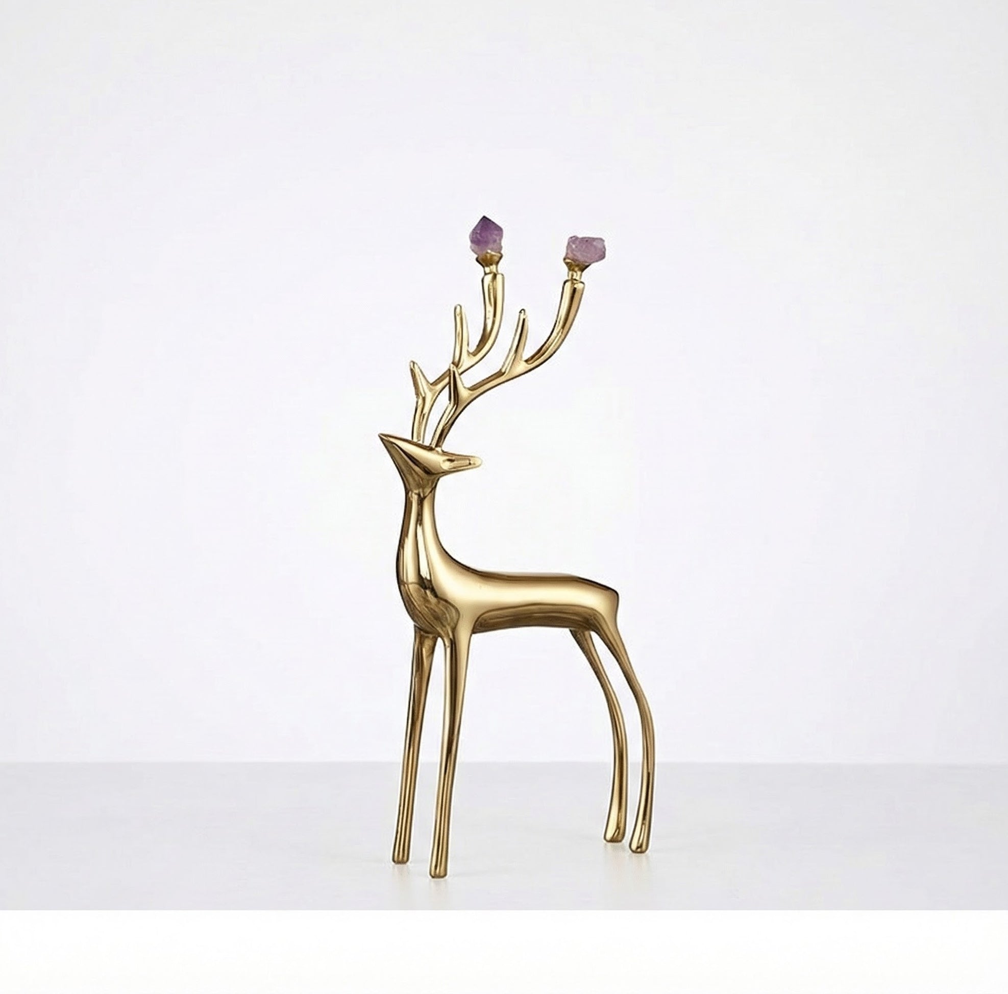 Single small copper deer sculpture with purple stones on the antlers against a white background