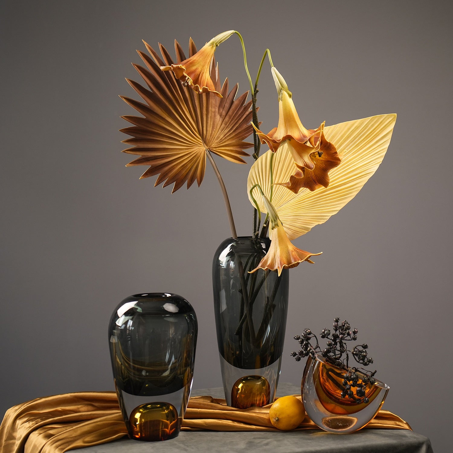 Smoke grey and amber glass vases styled with dried palm leaves