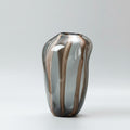 Close up of large smoke grey organic glass vase with amber stripes
