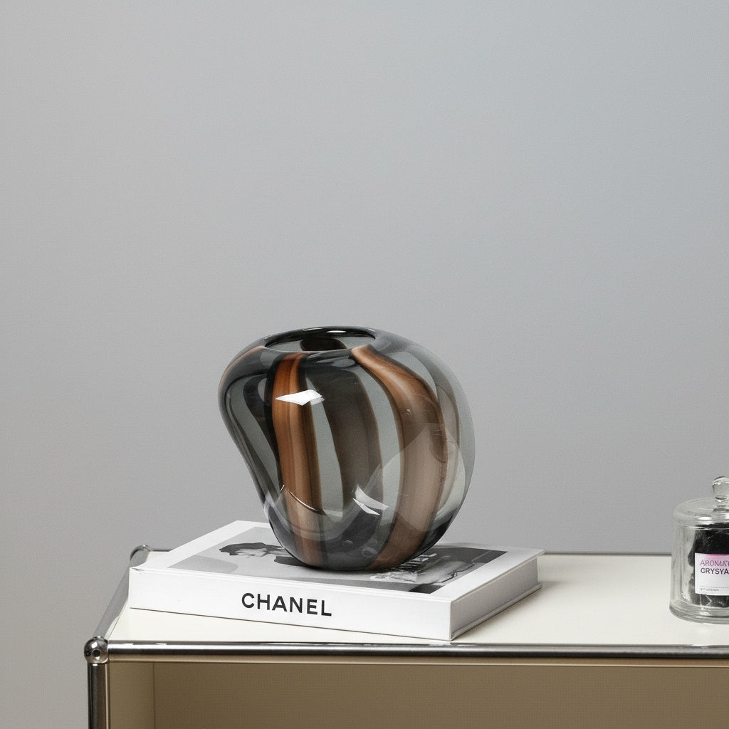 Medium smoke grey and amber striped glass vase on white book