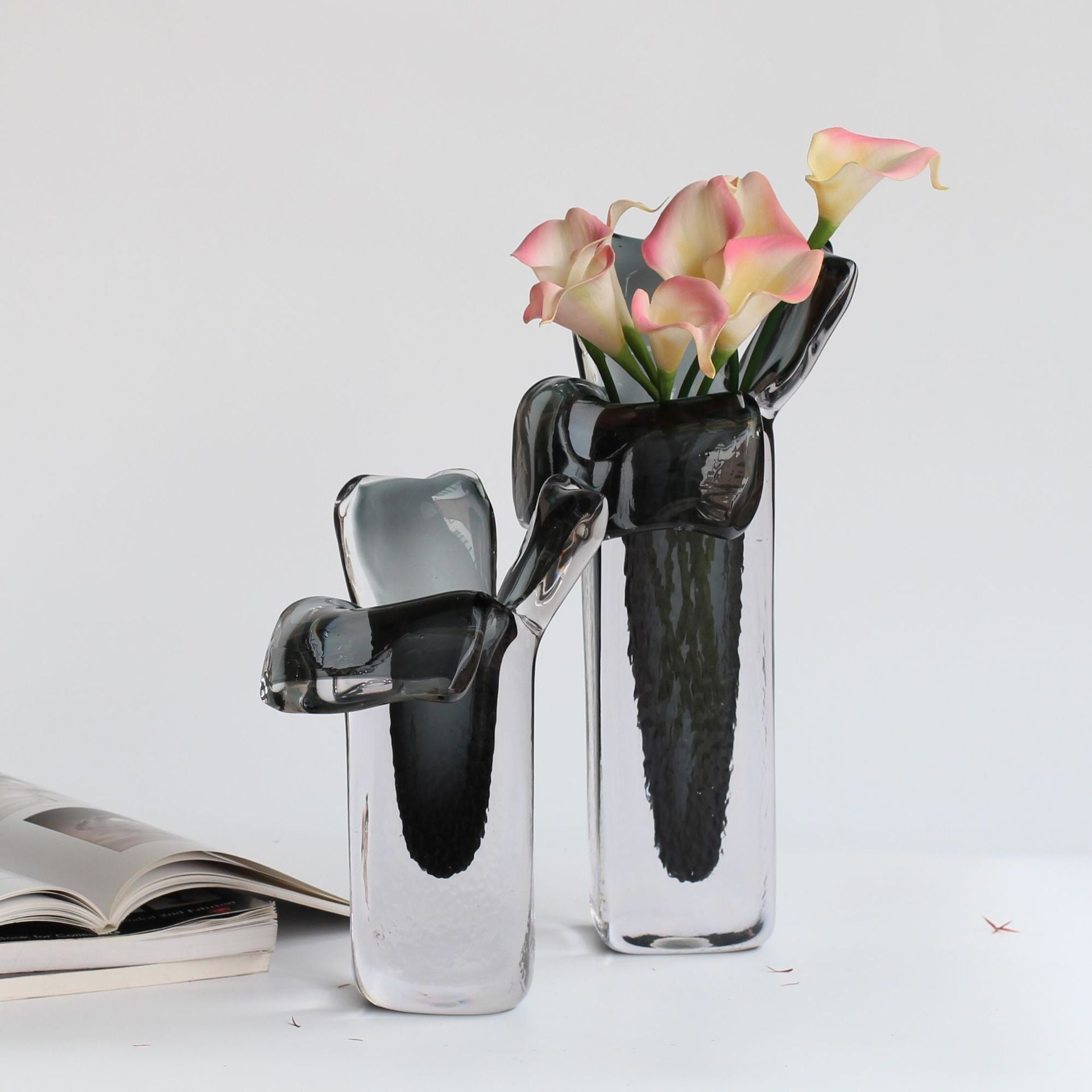 Large and medium glass vases styled with pink calla lilies