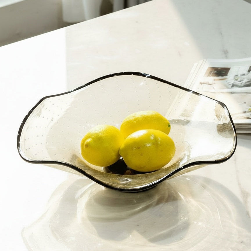 Side profile of wavy rim glass bowl on marble table