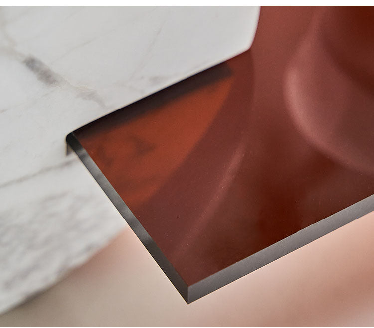 Close up detail of translucent smoked amber acrylic shelf joining white marble base