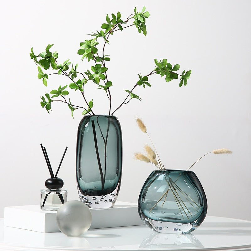 Lifestyle arrangement of smoked bubble glass vases with greenery