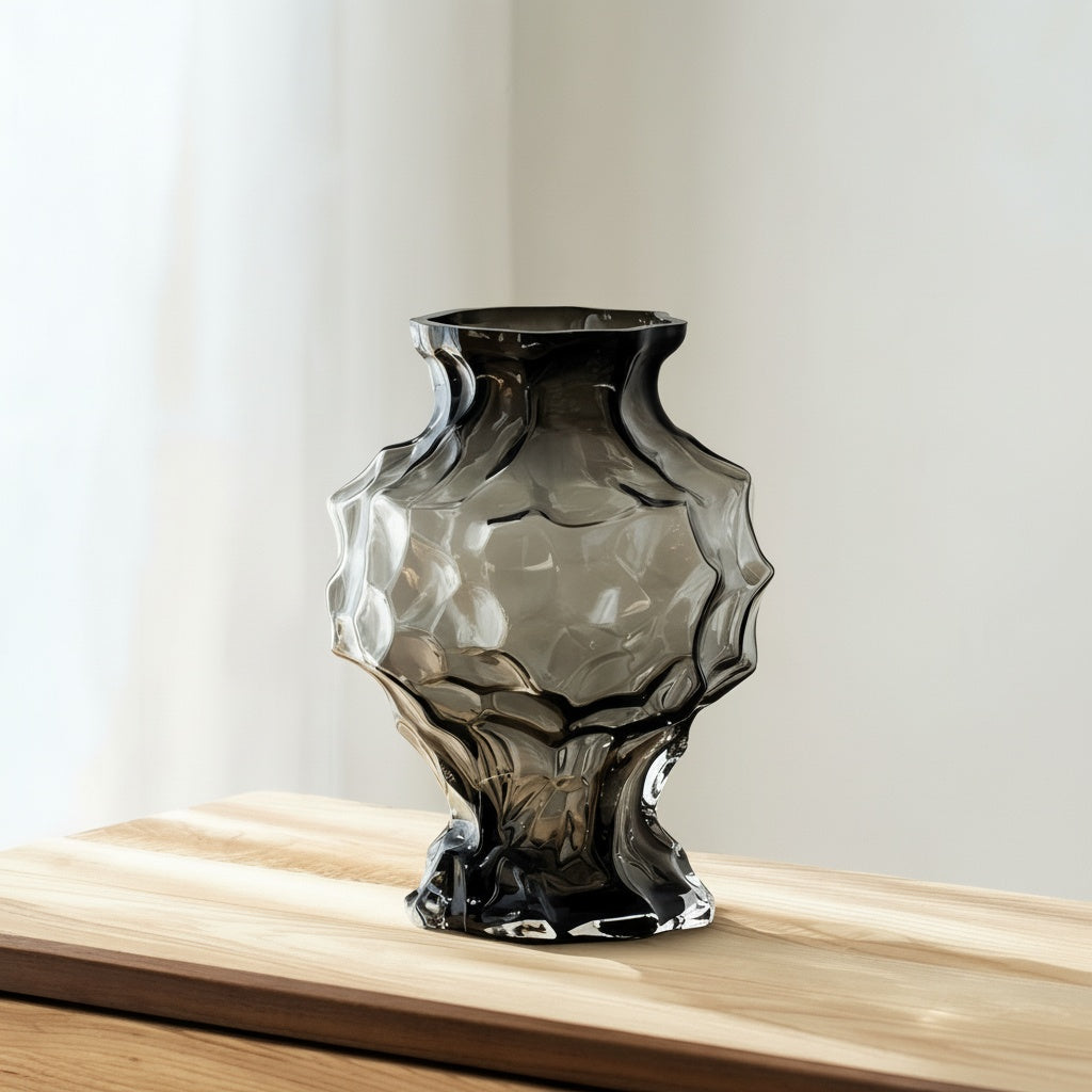 Smoked glass sculptural vase on a wooden surface