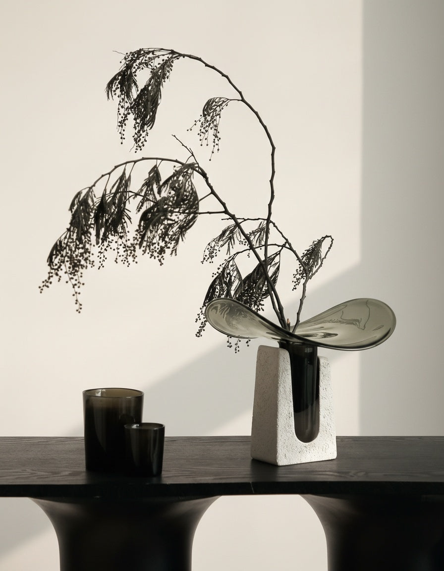 Smoked glass vase with stone base styled with botanicals