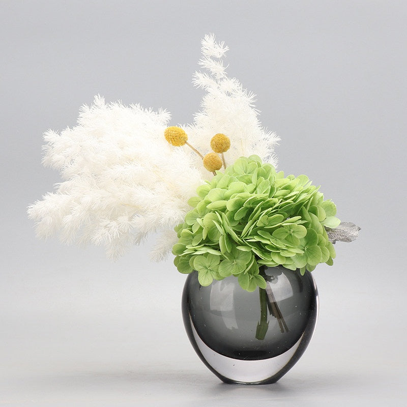 Smoked glass round vase with green hydrangea and white pampas arrangement
