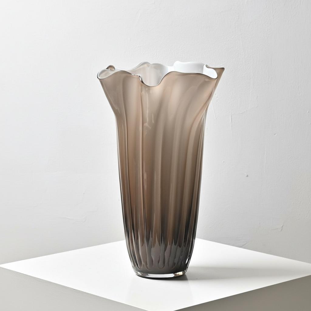 Close up of large smoked grey fluted glass vase with organic ruffled rim
