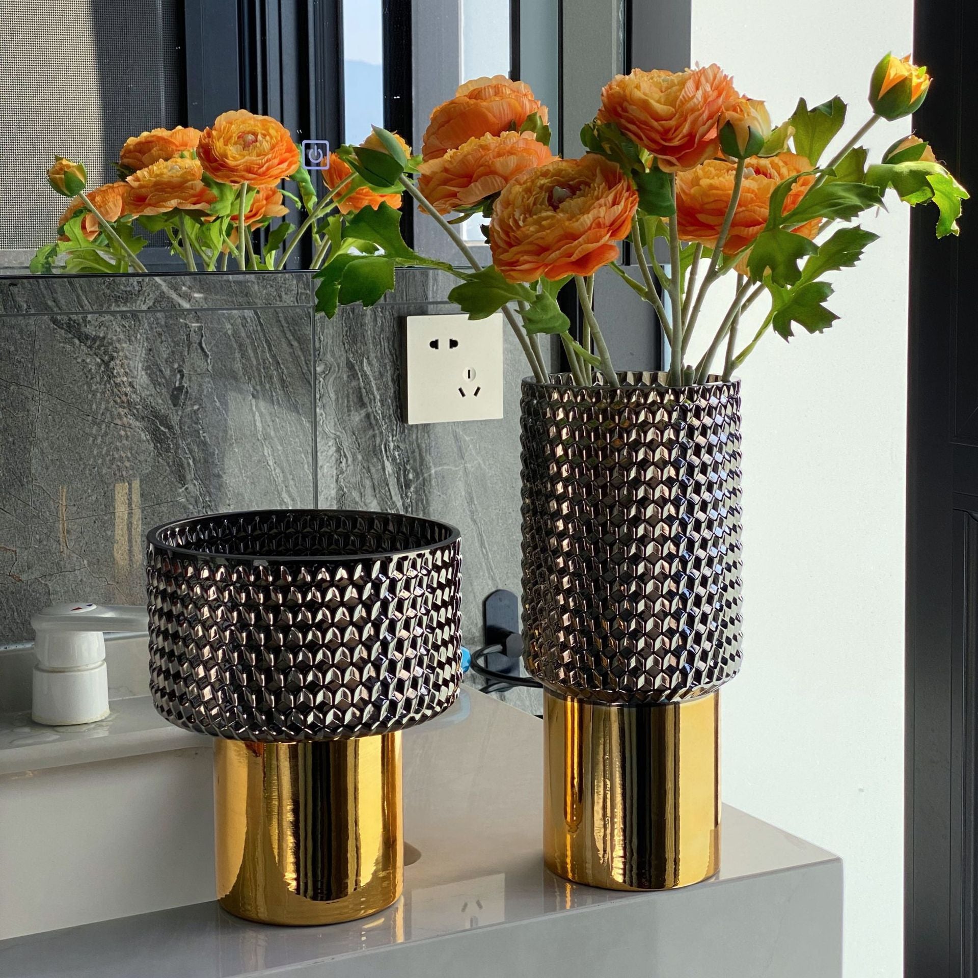 Smoky textured glass vase with gold base set on vanity