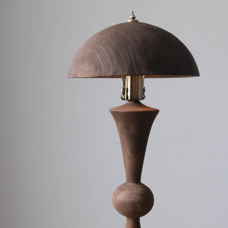 Close up of sculptural wood base and dome shade unlit