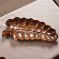 Top view of solid wood leaf shaped serving tray showing rich grain patterns