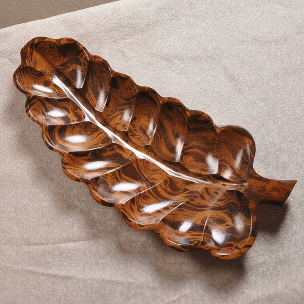 Angled view of polished wooden leaf platter serving dish