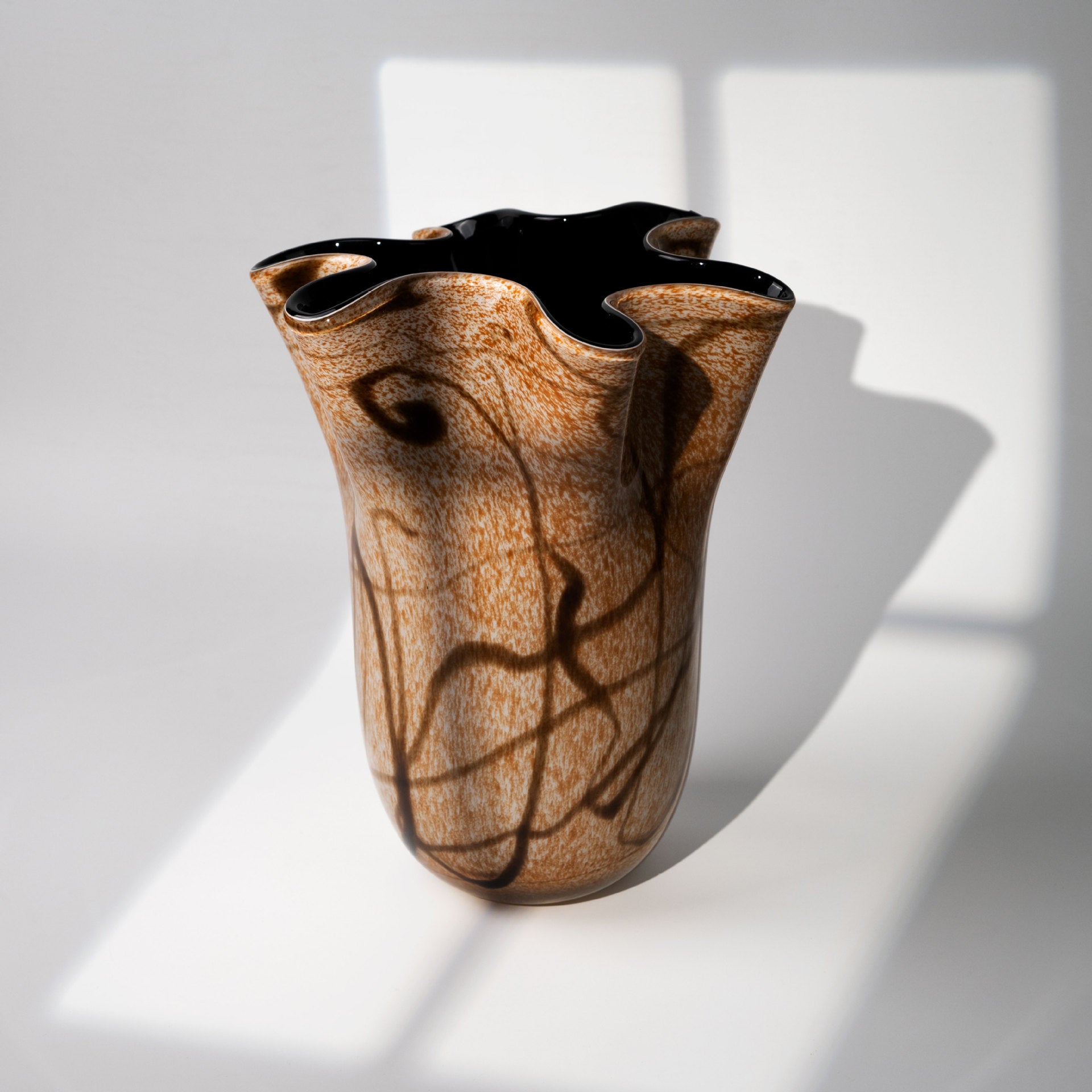 Speckled amber art glass vase with wavy rim top view