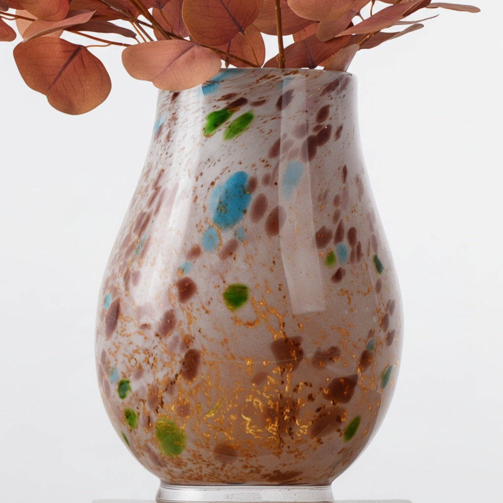 Detail of speckled art glass vase featuring blue and green spots with dried foliage