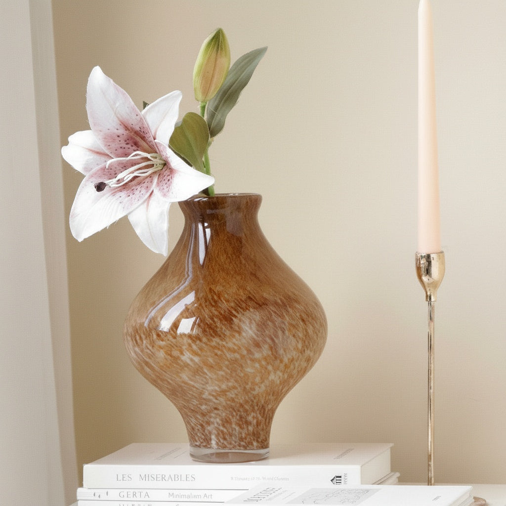 Speckled amber glass bulbous vase with floral arrangement