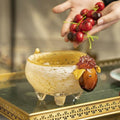 Glass sheep bowl being filled with cherries
