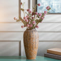Speckled amber glazed tall ceramic vase styled with flowers