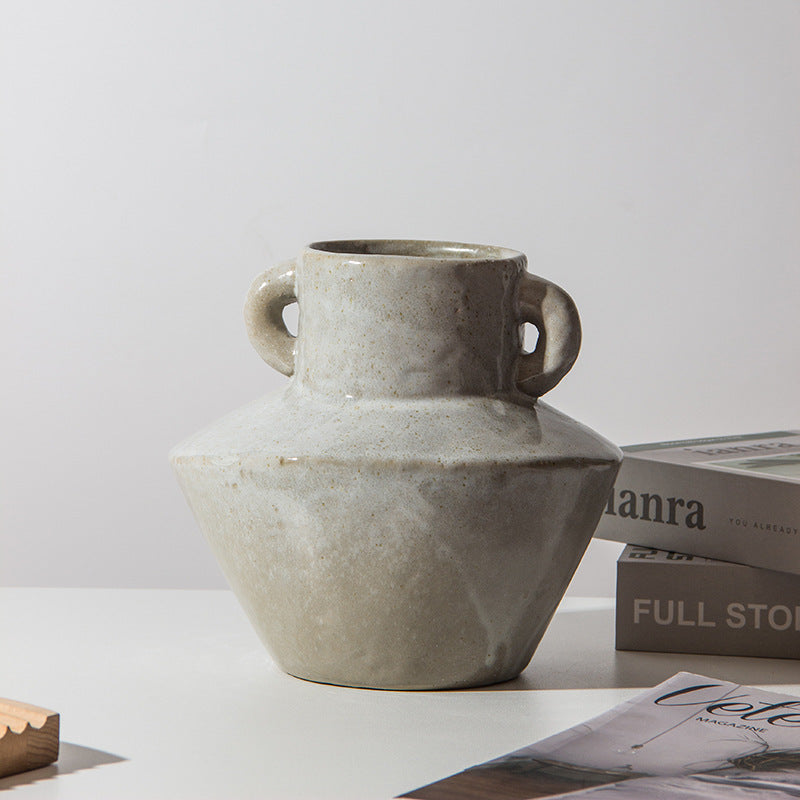 Lifestyle view of beige vase next to books