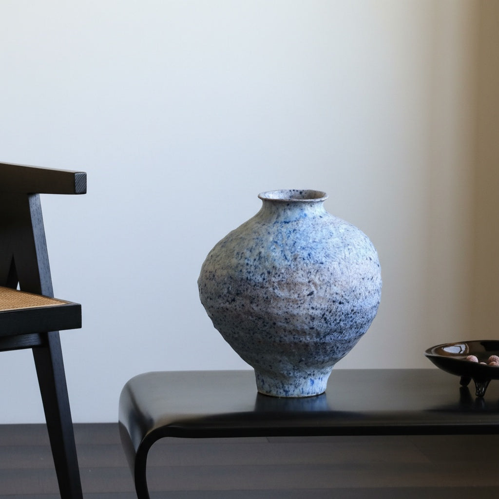 Ceramic vase styled on black bench in modern interior