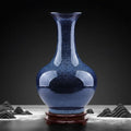 Speckled blue ceramic bottle vase on wooden stand