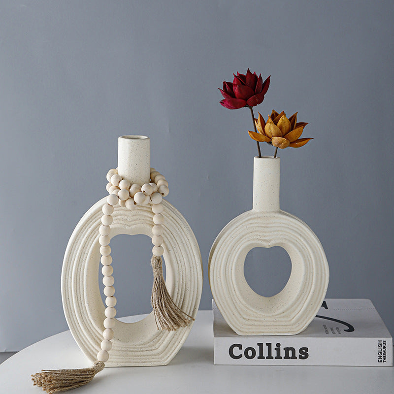 Two textured cream ceramic vases with heart cutout styled on books
