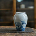 Close up of speckled ceramic vase with blue lotus design