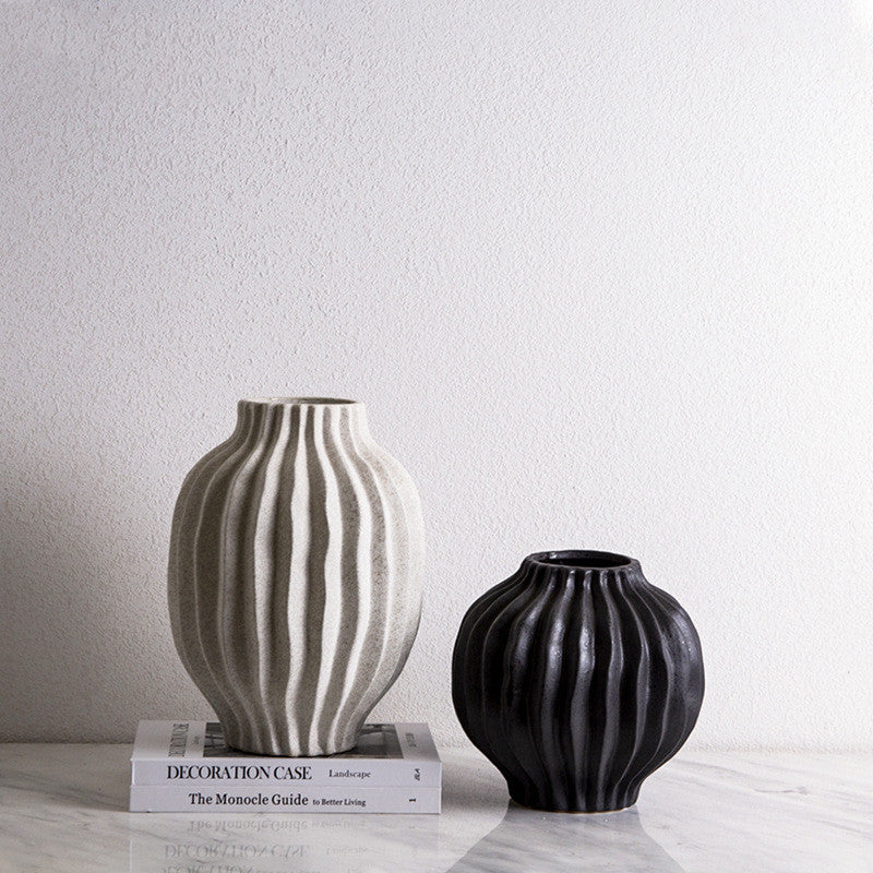 White and black ceramic ribbed vases displayed together without flowers