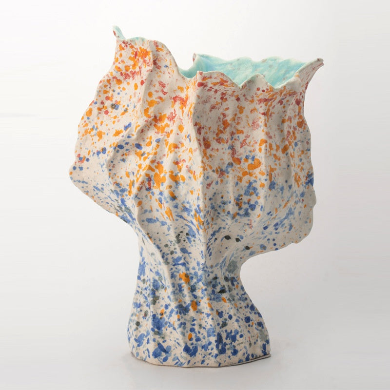 Front view of the speckled ceramic vase showing the crumpled organic form and splatter pattern
