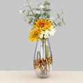 Large tapered glass vase with yellow flowers and confetti pattern