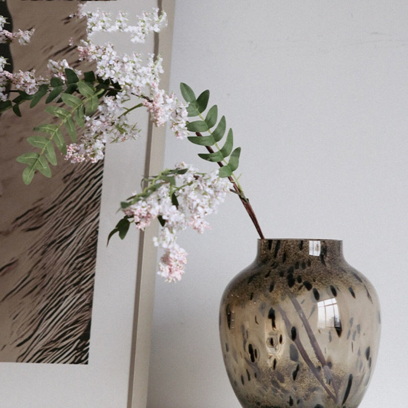 Brown speckled glass vase with white flowers