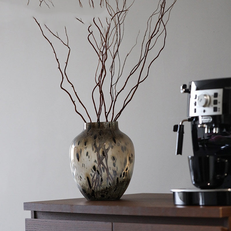 Brown glass vase on wooden sideboard